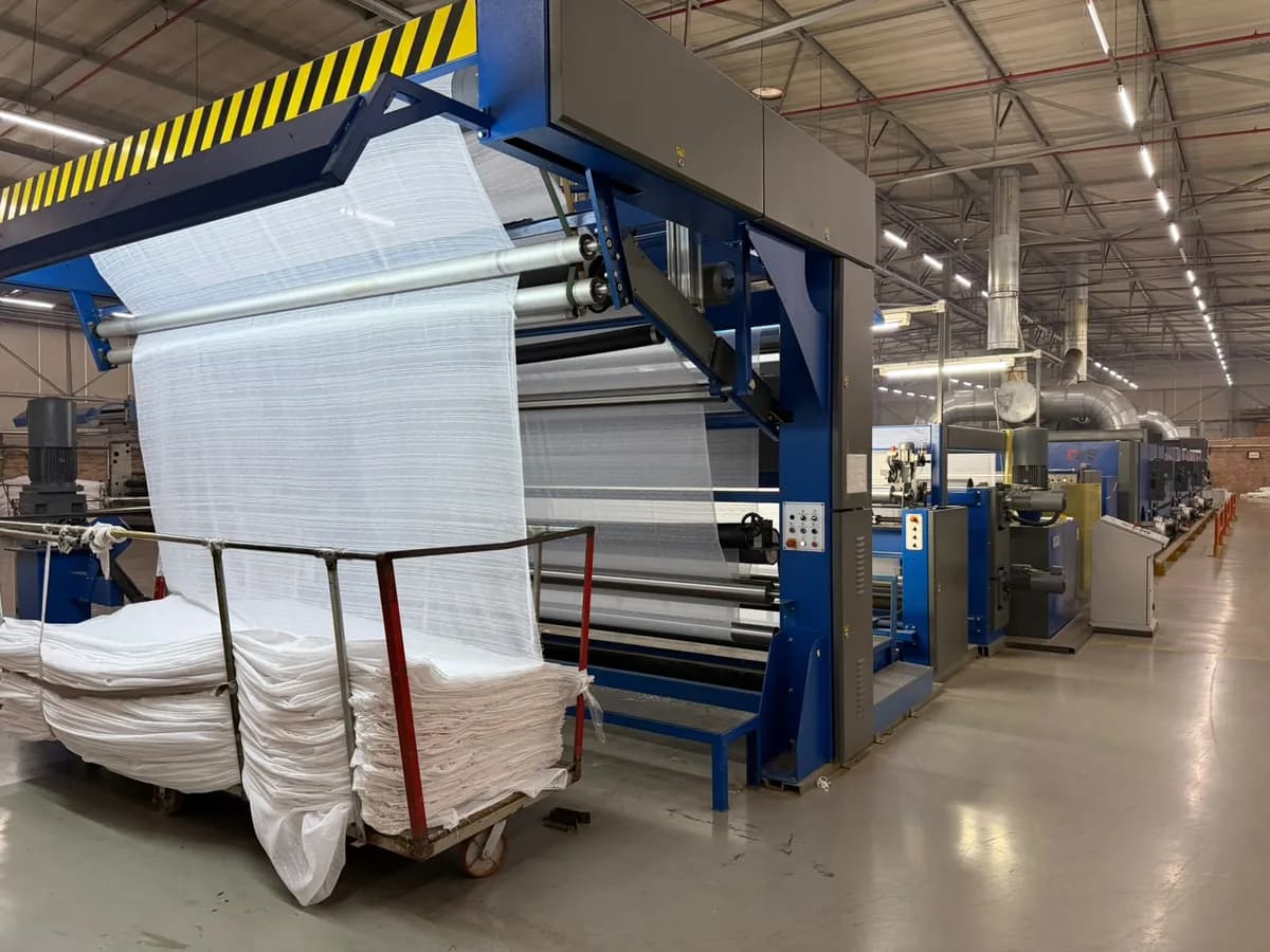Fabric feeding through the stenter on the Korteks Textiles Africa dyeing & finishing line