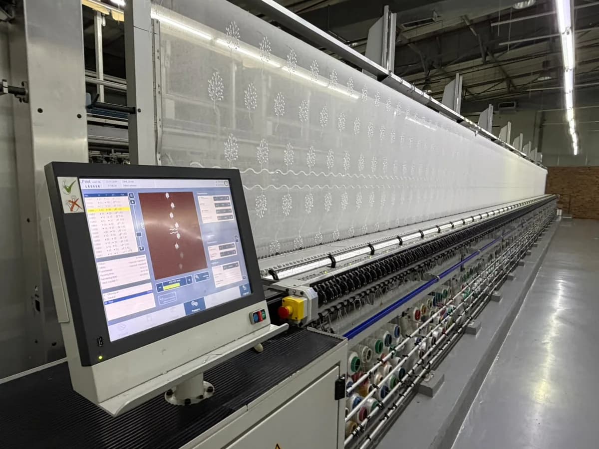 A Lässer Schiffli embroidery machine embroidering patterned fabric at Korteks Textiles Africa