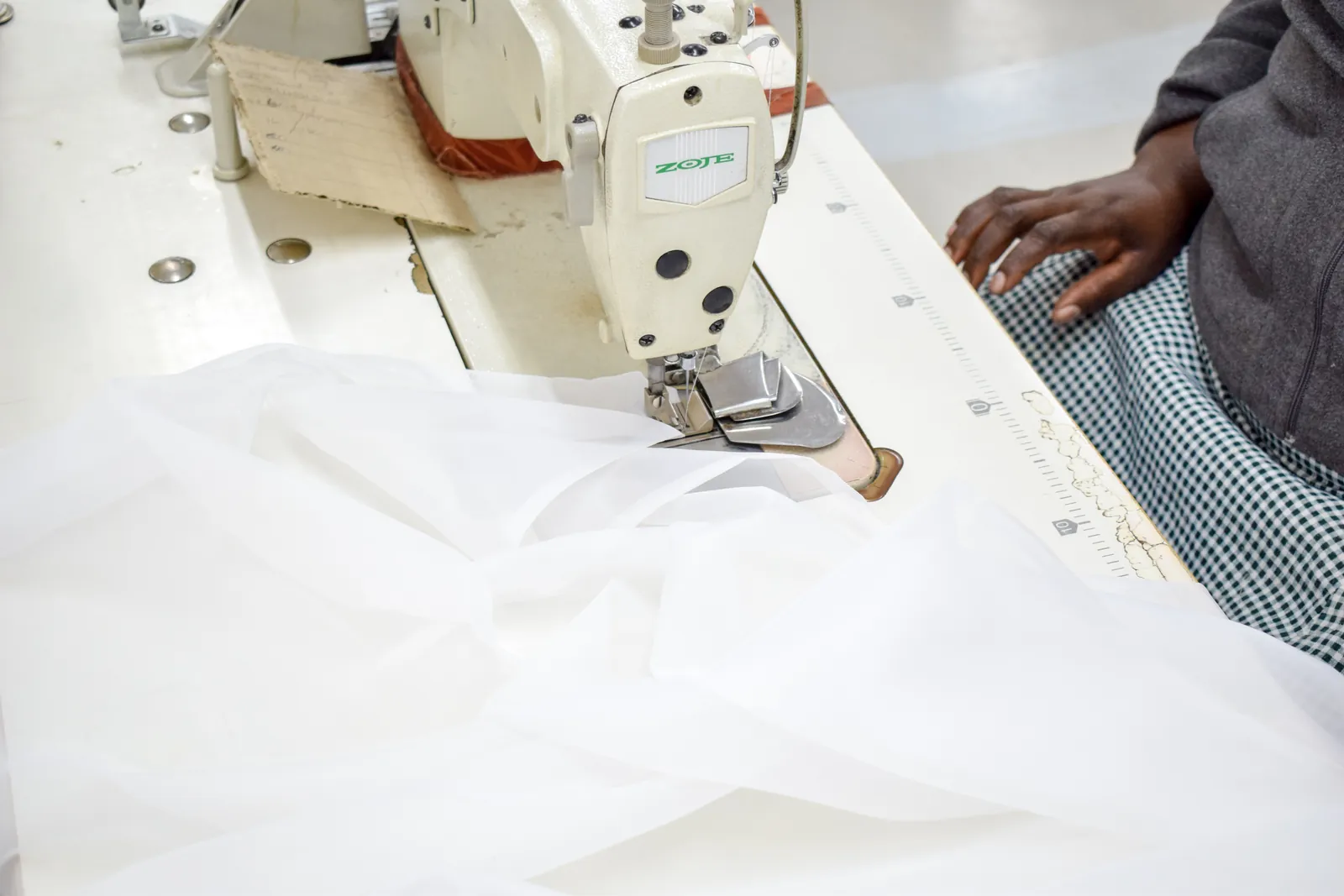 A sheer curtain being sewn on an industrial machine on the Zaydtex CMT floor