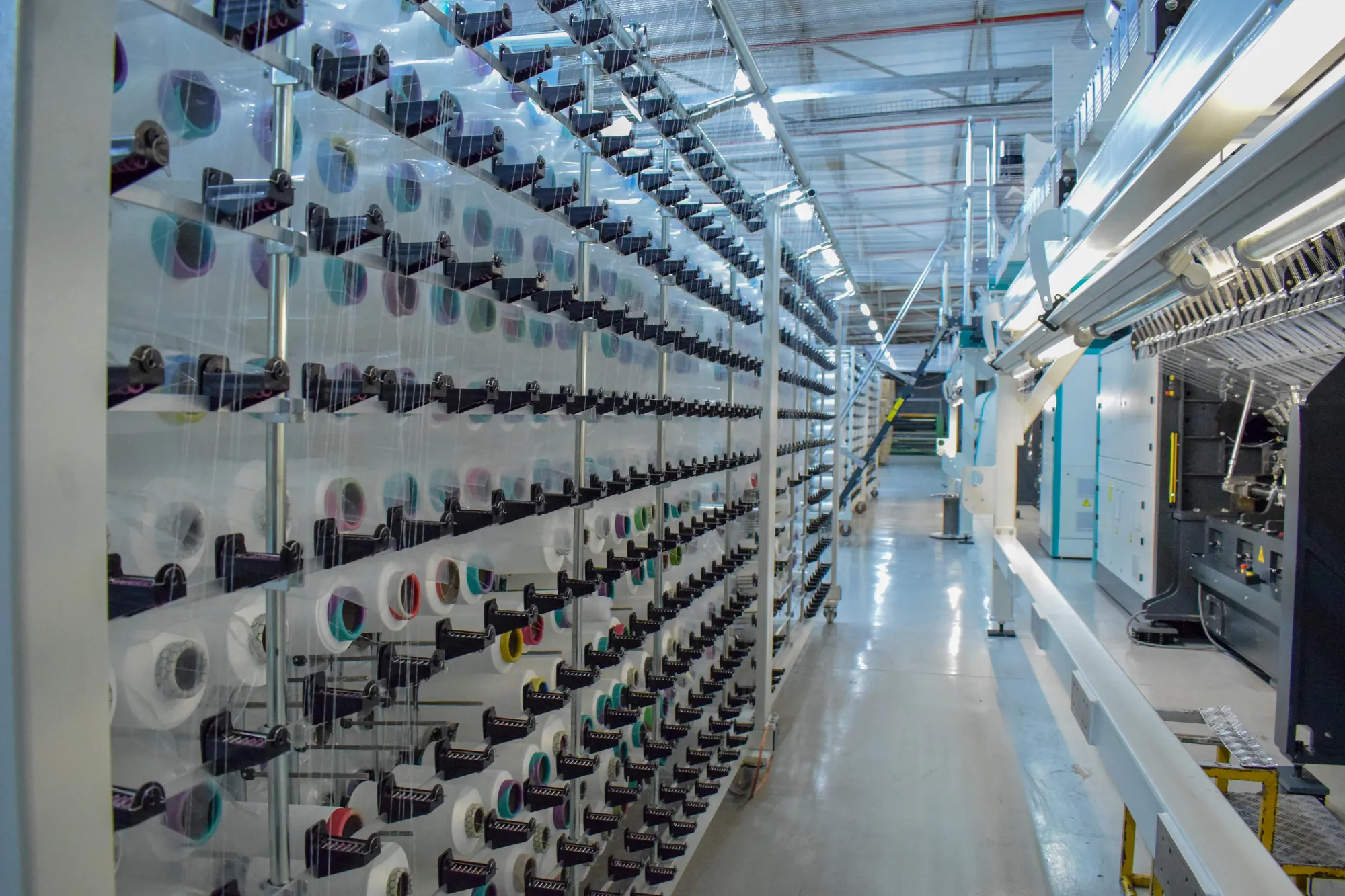 The vast warping creel hall at Korteks Textiles Africa, lined with thousands of yarn packages running to a vanishing point