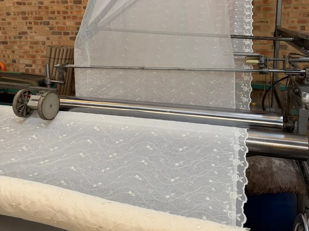 Embroidered Zaydtex voile being measured and rolled off the machine, sold by the metre